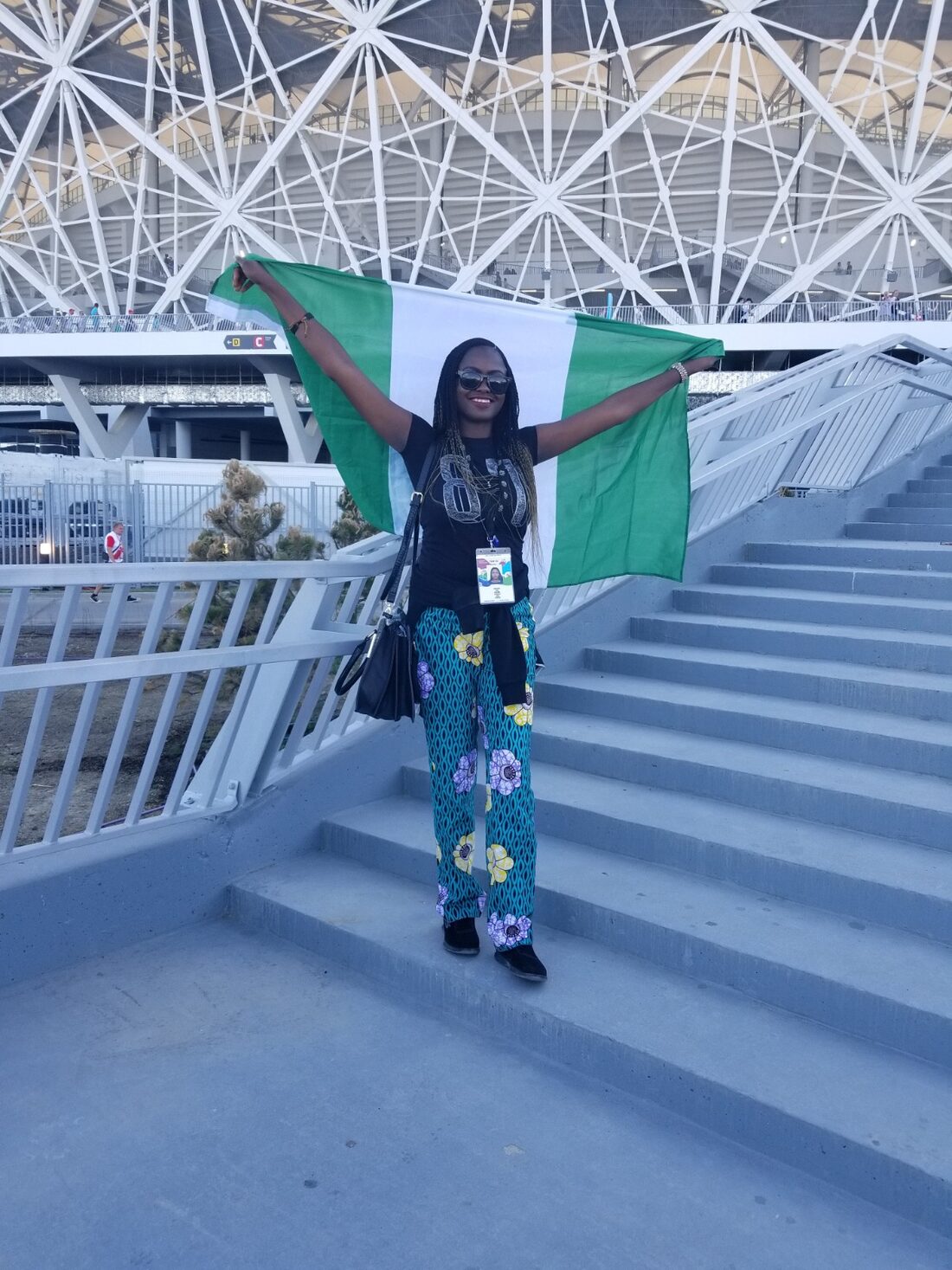 Taiwo holding the Nigerian flag at a FIFA World Cup stadium